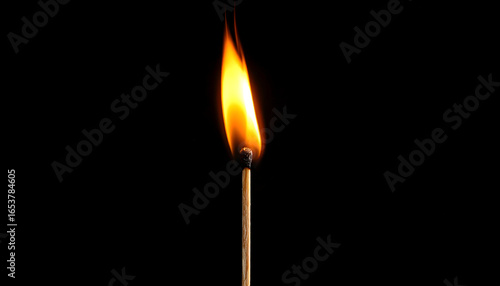 Burning Matchstick with Bright Orange and Yellow Flame Against a Black Background