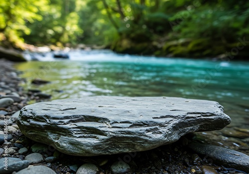 Mockup a large rock sits on the bank of a clear blue river in a forest commercial usage