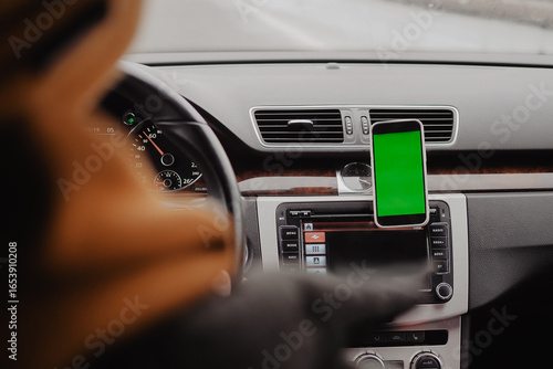 Millennial man drive the car and using mobile app , green screen