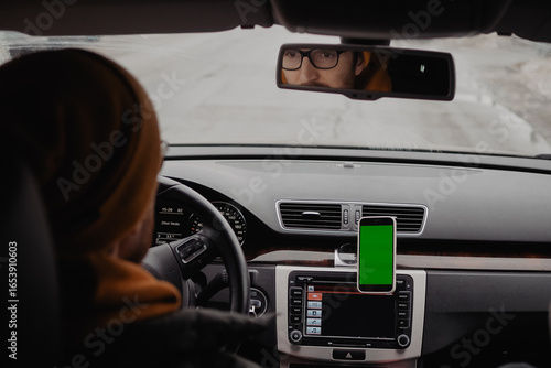Millennial man drive the car and using mobile app , green screen