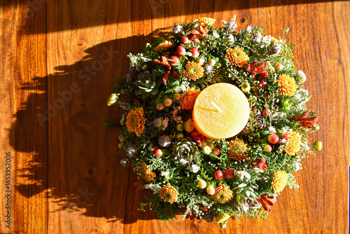 Ein Adventskranz auf einem Holztisch wirft einen langen Schatten im Sonnenschein