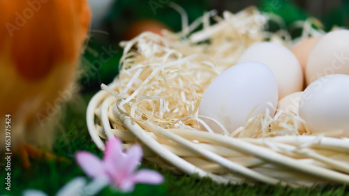 Close-up of eggs in a straw nest with decorative spring details, symbolizing Easter, new life and rural tradition
