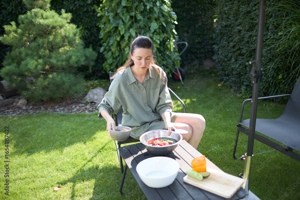 Fototapeta premium Woman cooking in her backyard
