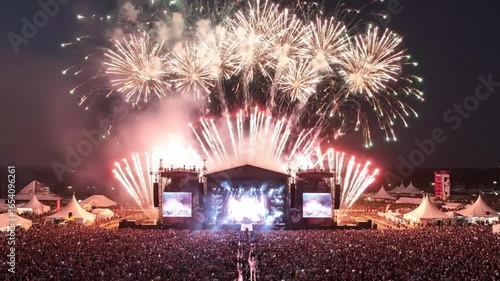 A spectacular aerial view of a grand fireworks finale over the main stage and crowd at a music festival, a magical closing ceremony.