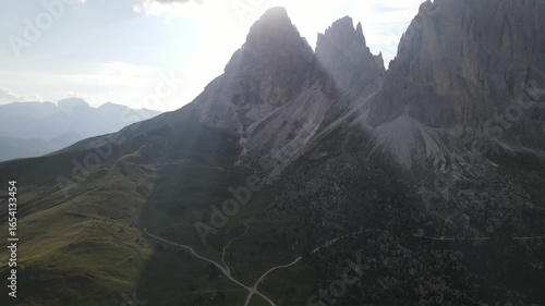 mountains dolomites italy alps bright sunrise at dawn from behind mountain peaks summer against blue sky aerial view lens flares. Vista de las dolomitas Italia con Drone.