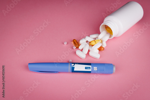 Top view of semaglutide pens with blue tape and white pill bottle on pink table, pills scattered, symbolizing wellness, telehealth, and patient care.