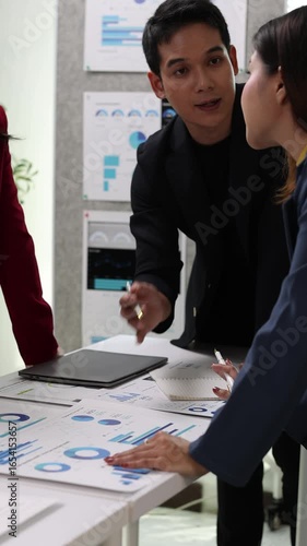 Business team analyzing financial data and strategic planning in office meeting.