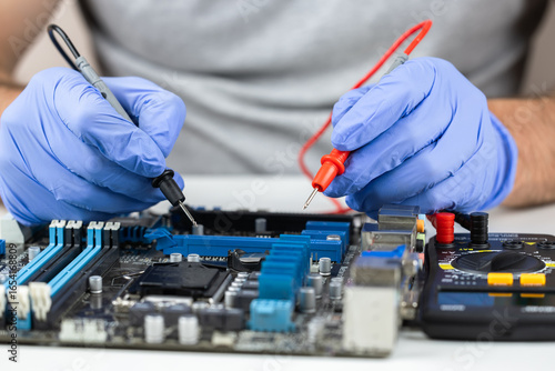 Wallpaper Mural Testing motherboard with probes and multimeter, Close-up of technician using probes on computer motherboard with multimeter Torontodigital.ca