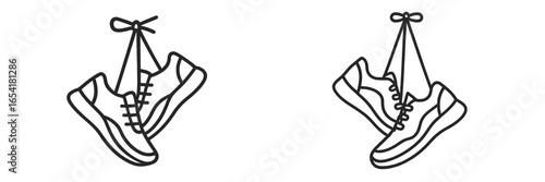 Sneakers hanging by laces on a wire in an urban setting during bright daylight