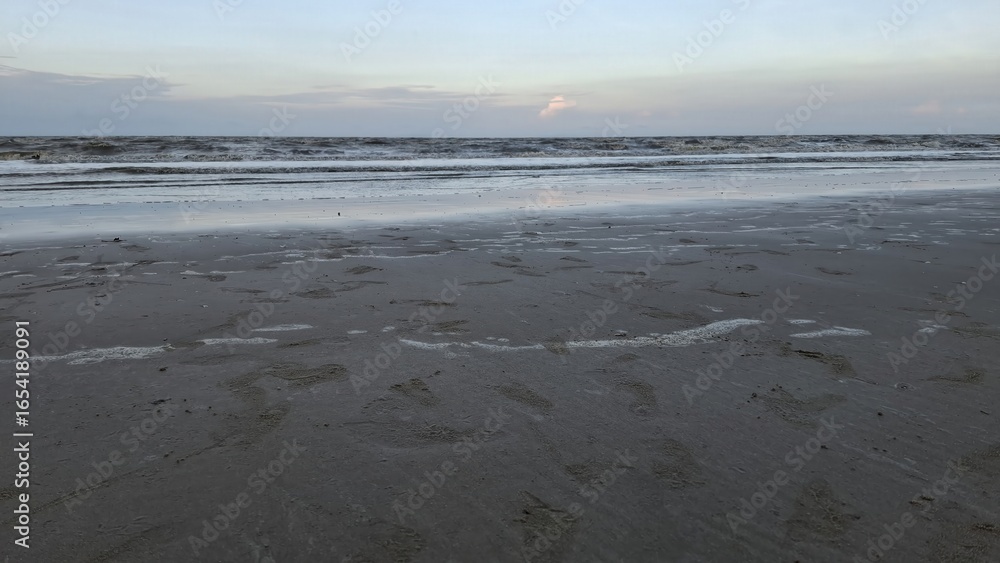 Obraz premium Serene ocean waves lapping on sandy beach coastal nature scene tranquil evening wide-angle view relaxing concept