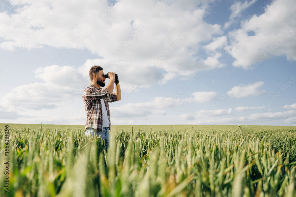 Using binoculars. Man farmer is on the agricultural field Using binoculars. Man farmer is on the agricultural field