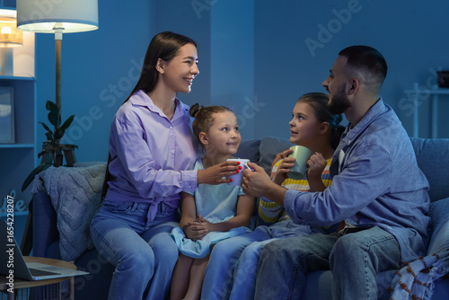 Happy family with cups of t...