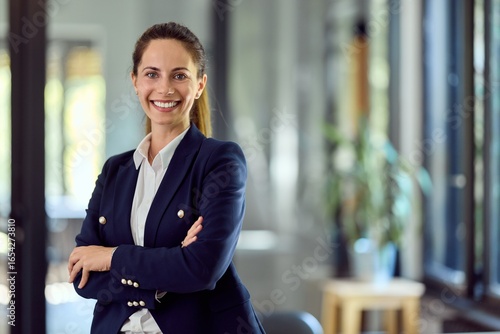 Canvastavla Confident Businesswoman Smiling in Modern Office Setting with Natural Light