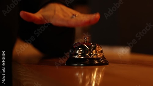 Close up hand of unrecognisable woman impatiently pressing the bell at hotel reception desk. Ring bell for customer service, hospitality and help. Check in, welcome and help with service alert.