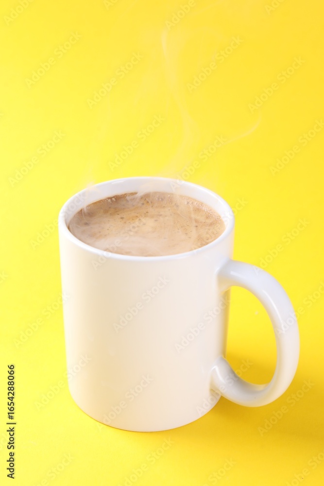 Obraz premium Aromatic coffee in cup on yellow background, closeup. Mockup for design