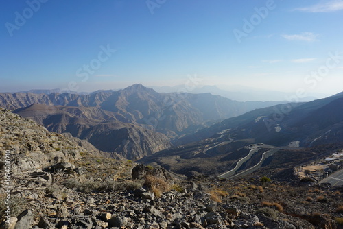 A winding mountain road through rocky terrain viewed from the hiking trail to the flag at Jebel Jais in the United Arab Emirates