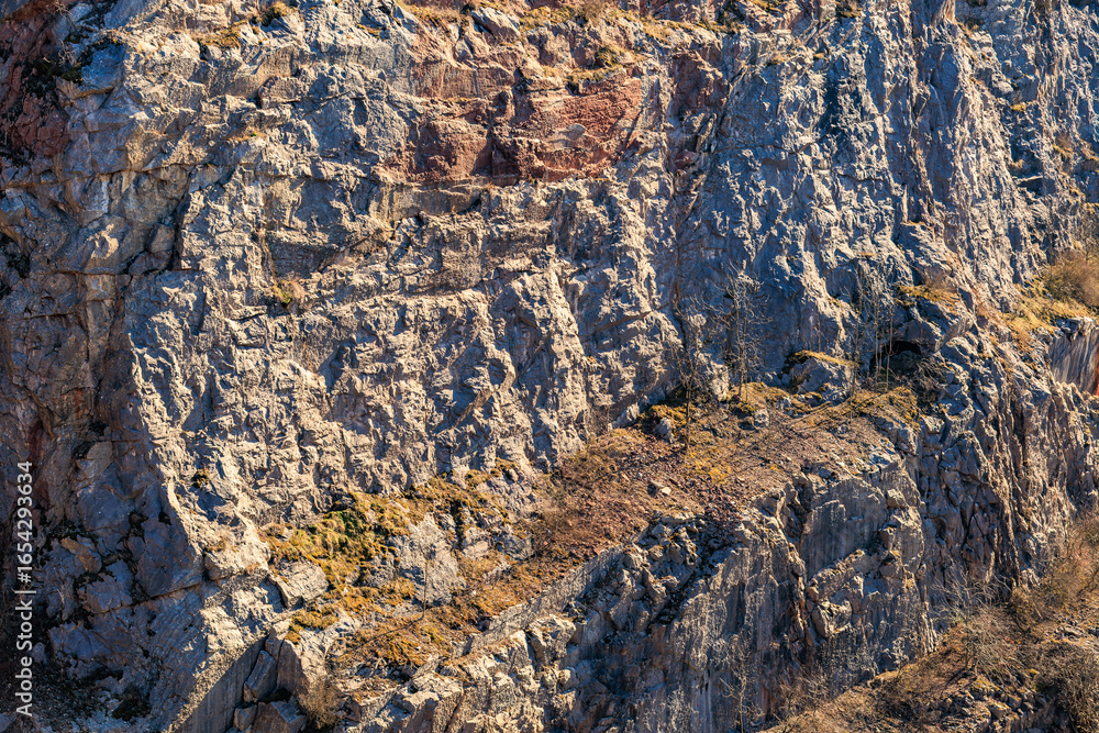 Fototapeta premium Rugged rocky cliff face with natural textures and erosion patterns