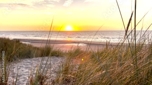 Sonnenuntergang an der Nordsee hinter den Dünen von De Haan in Belgien
