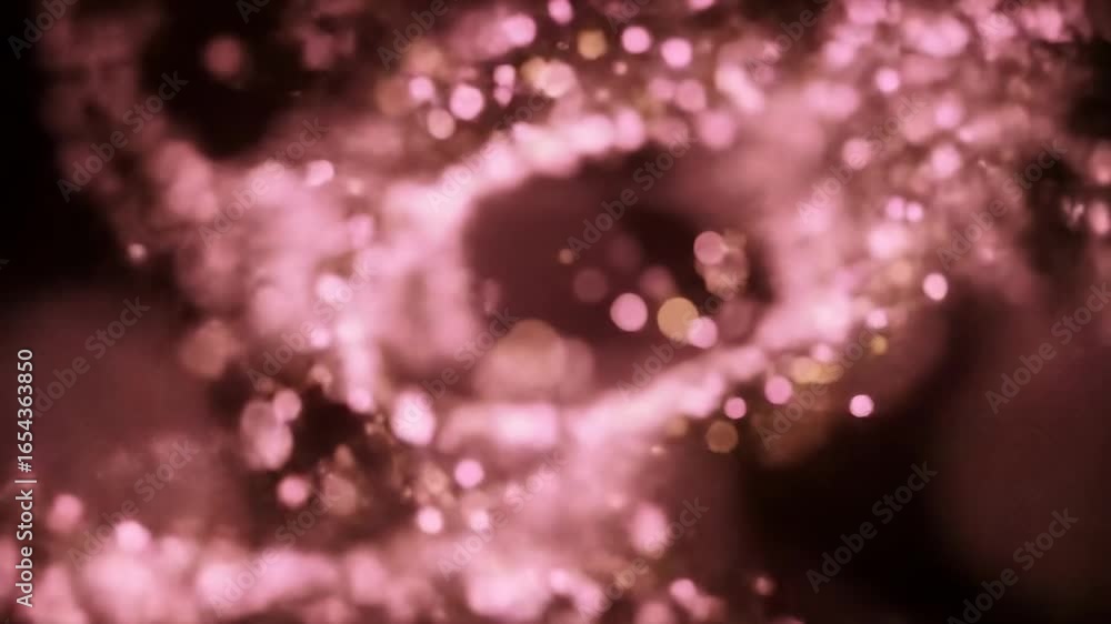 Abstract pink and gold bokeh swirls on black background Abstract pink and gold bokeh swirls on black background