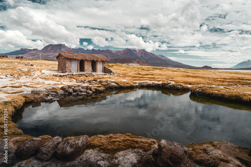 Rustikale Hütte in den Anden Gebäude am Wasserlauf mit Bergpanorama im Hochland von Salinas Aguada Blanca