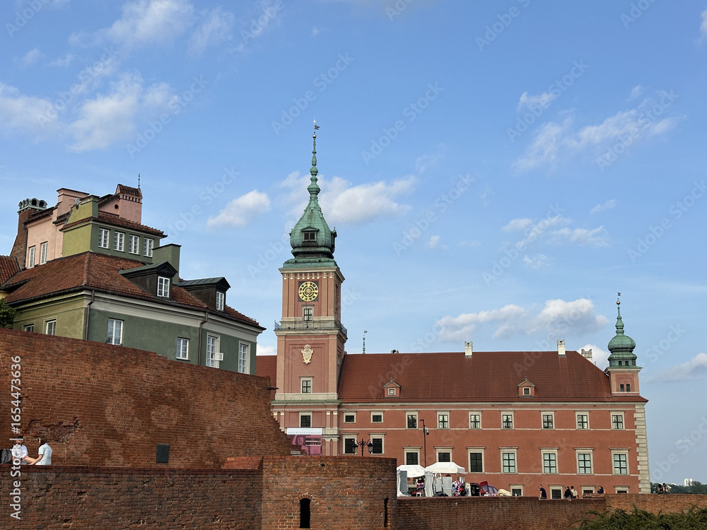 Obraz premium Historic Royal Castle in Warsaw, Poland, showcases stunning architecture with a clock tower and vibrant sky, a symbol of cultural heritage and history