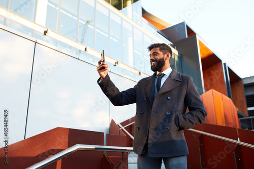 Indian businessman video conferencing outdoors in city