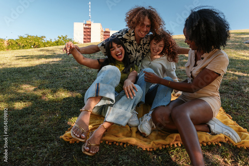 Photography Friends laughing together during outdoor gathering in a park