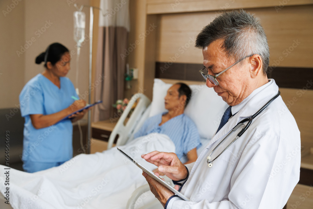 Obraz premium asian senior male professional doctor using tablet for digital health record and nurse writes notes beside patient. hospital room equipped medical instruments and IV drip. healthcare and treatment.