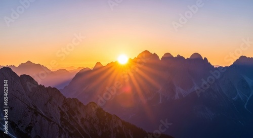 Breathtaking Sunrise Over Majestic Mountain Peaks with Vibrant Colors and Sunbeam Rays Illuminating the Scenic Landscape at Dawn