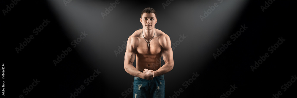 Fototapeta premium Muscular Man in Spotlight on Wide Banner