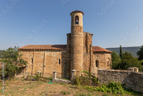 Valderredible, Spain. Side view of the Romanesque collegiate church of San Martin de Elines with its cylindrical bell tower, ashlar masonry and a cornice decorated with corbels