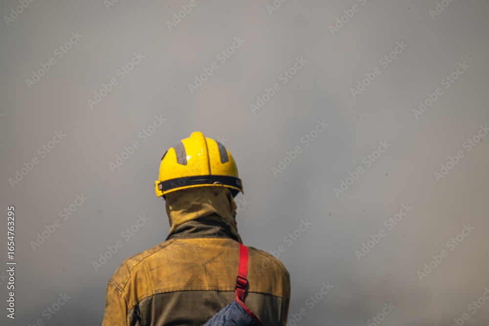 Fototapeta premium The Silhouette of a Fireman in a Dense Fog. Concept Bravery in zero visibility.