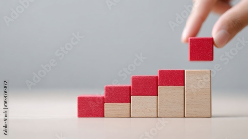 A person is holding a red block and breaking it into smaller pieces