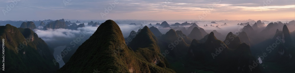Obraz premium Majestic mountains with mist at sunrise: serene landscape and river view