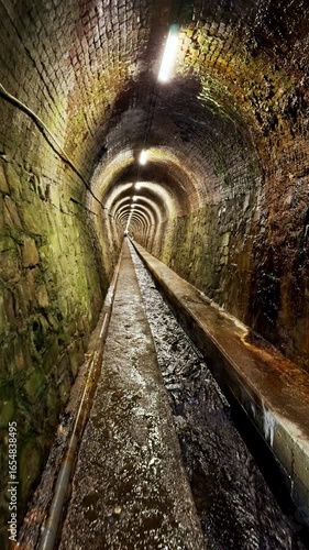 Water flowing through narrow brick drainage tunnel