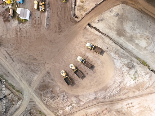Aerial View of Construction Site with Heavy Equipment and Dump Trucks – Industrial Earthmoving and Mining Operation