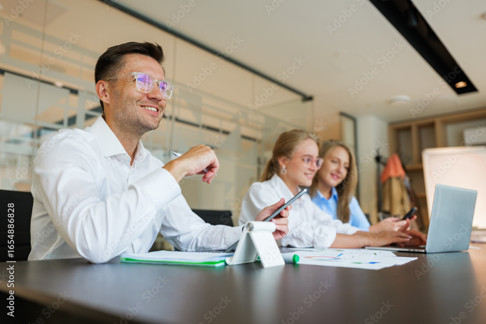 Obraz premium Team collaboration in a modern office during a productive meeting with technology in use and smiling faces