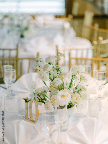 Foto Elegant wedding table arrangement with white flowers and gold accents during a d
