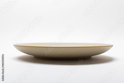 a white bowl with a yellow rim on a white surface