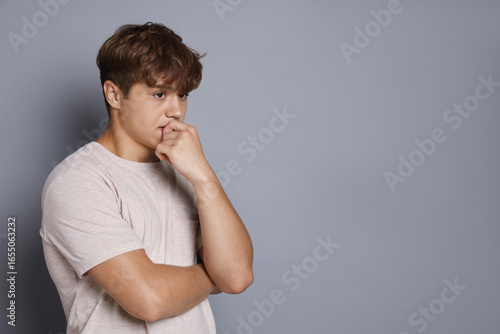 Photos Teenage boy suffering from panic attack on grey background