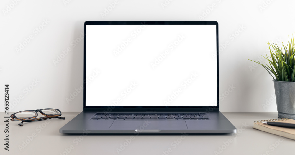 Fototapeta premium Modern laptop with blank white screen on minimalist desk. Mock up template