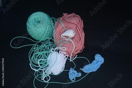 Colorful yarn and crochet tools arranged on black surface