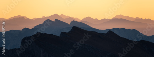 Layers of mountain peaks in the dolomites during sunrise.