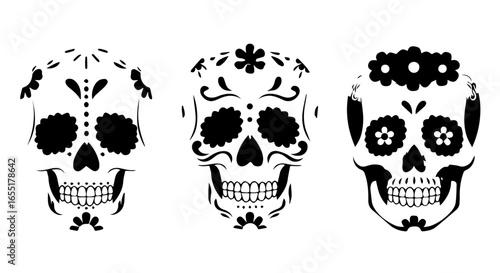 Set of three black and white Day of the Dead sugar skulls with ornate floral and swirl decorations.