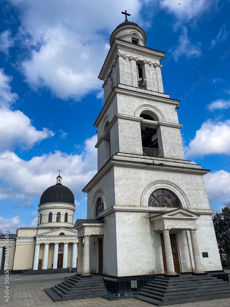 Fototapeta premium White bell tower and cathedral under blue sky