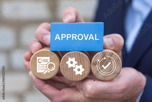 Tableau sur toile Business person holding wooden blocks with icons sees the word APPROVAL