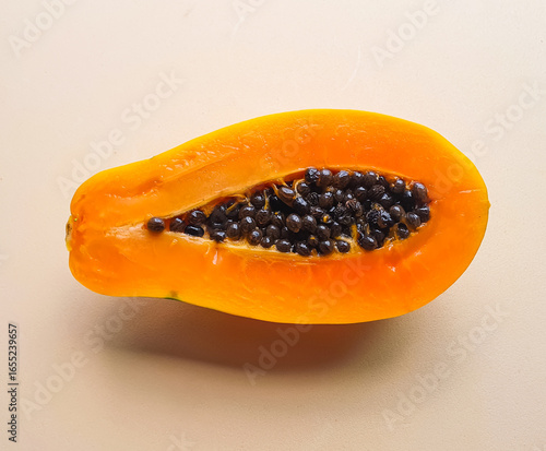 open papaya with seeds on a light beige background