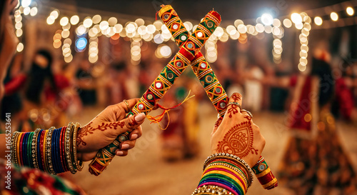 Close Up of Woman's Hands Holding Dandiya Sticks,  Blurred Background with Bokeh and Dancers