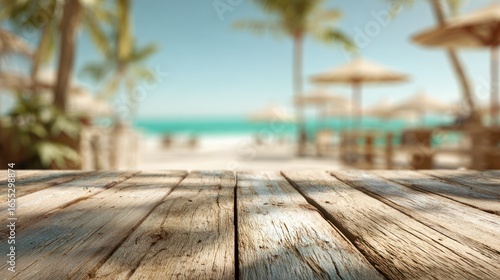 Tropical beach scene; wooden deck. Blurred beach and palm trees, sunny day