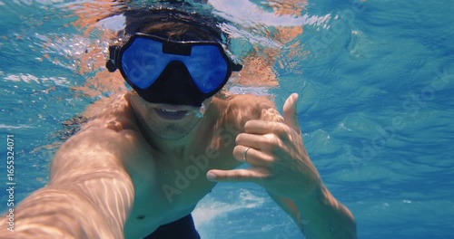 POV man snorkeling and swimming underwater in tropical ocean water on summer vacation 